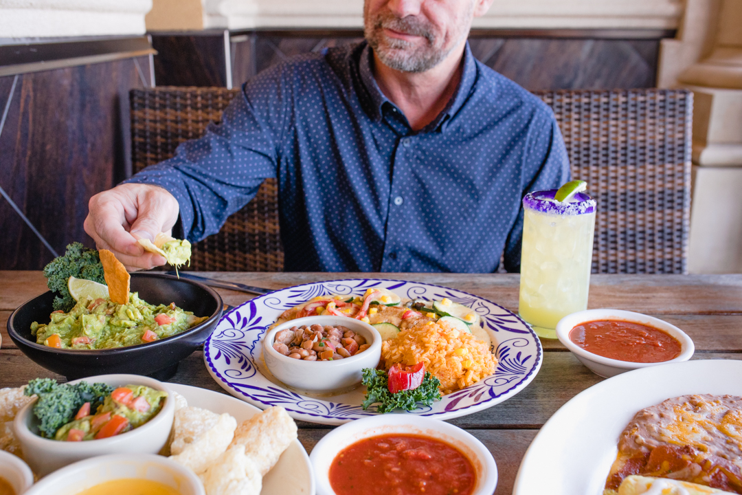 Man sitting at table with a selection of Abuelo's menu items